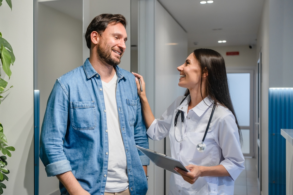 Doctor with patient smiling in corridor